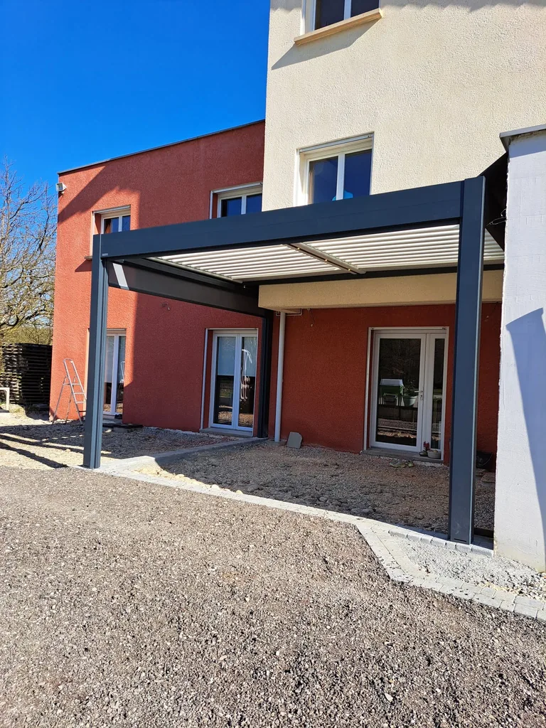 Pergola bioclimatique vue depuis la terrasse, lames blanches orientables et structure anthracite