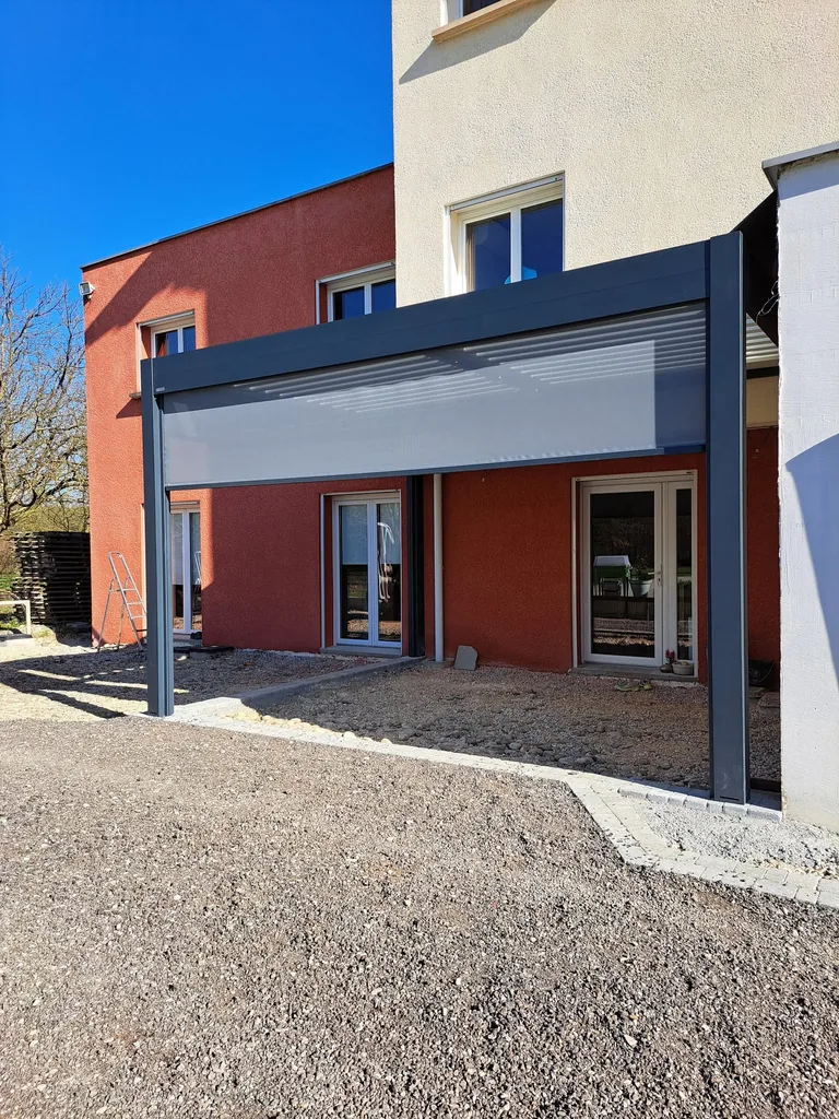 Store screen motorisé déployé sur le côté de la pergola bioclimatique
