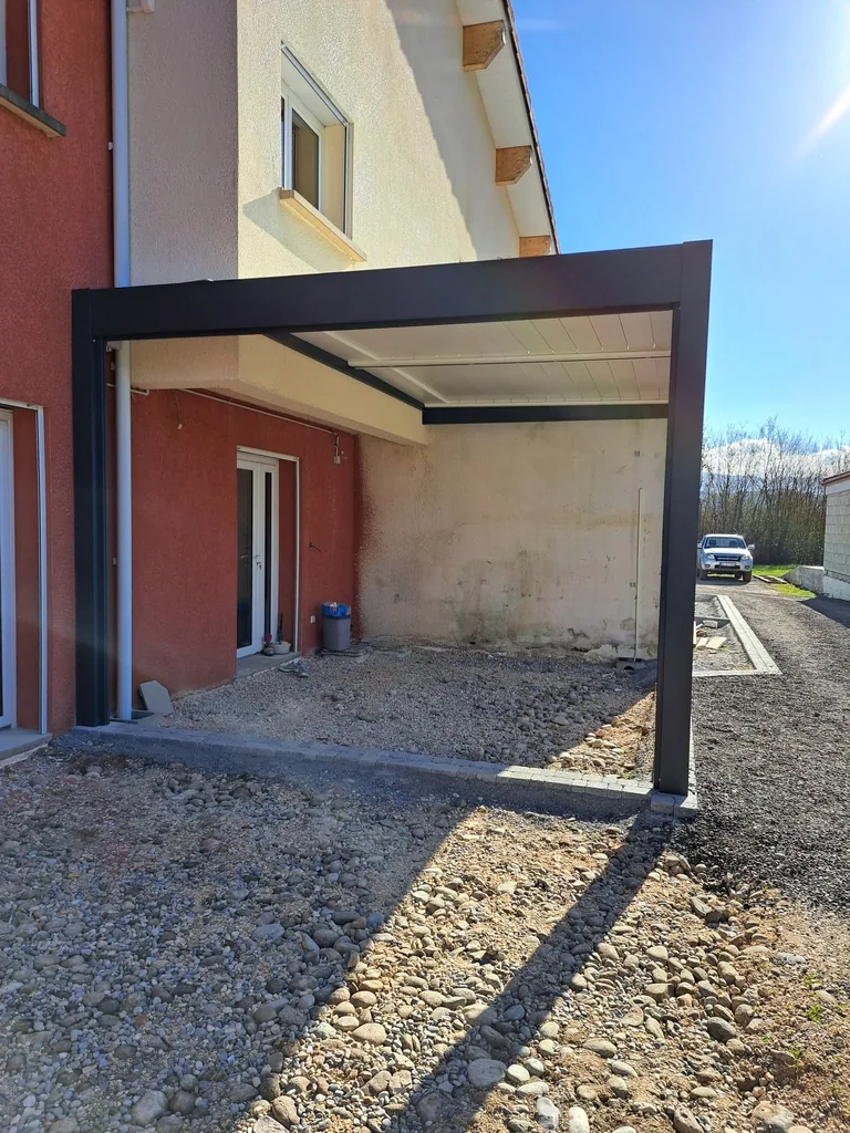 Pergola bioclimatique adossée à la façade, vue de l’angle de la maison